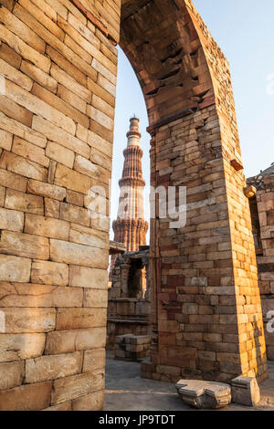 Die berühmten Qutb Minar in Delhi, Indien gesehen durch einen Torbogen in der Qutb-Komplex, ein UNESCO-Weltkulturerbe. Stockfoto