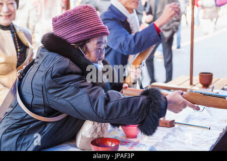 Japan, Honshu, Tokio, Asakusa, ältere Dame mit Pop Gun auf Tempel-Messe Stockfoto