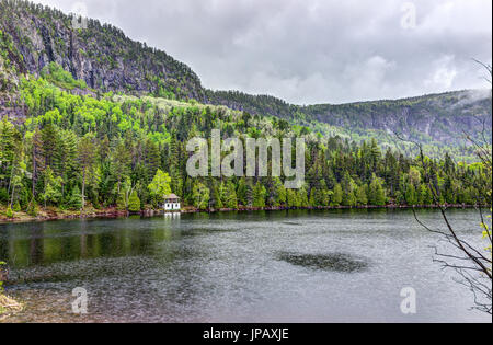 Haus am See im Sommerlandschaft von Wasser während der regnerischen bewölkten Tag in Quebec, Kanada Stockfoto