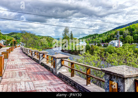 Petit-Saguenay, Kanada-2. Juni 2017: Holzsteg Terrasse Gehweg Fluss in Québec Dorf rot lackiert Stockfoto