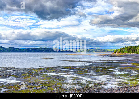 Fjord in Saguenay River Nahaufnahme von Strand mit seichtem Wasser und bewölktem Himmel Stockfoto