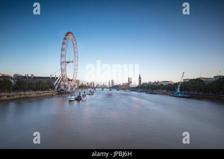 Blick auf die Themse mit dem London Eye, Big Ben und Westminster Palace im Hintergrund in der Dämmerung London Vereinigtes Königreich Stockfoto