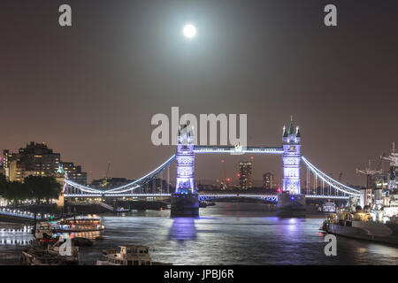 Vollmond auf der beleuchteten Tower Bridge spiegelt sich im Fluss Themse London Vereinigtes Königreich Stockfoto