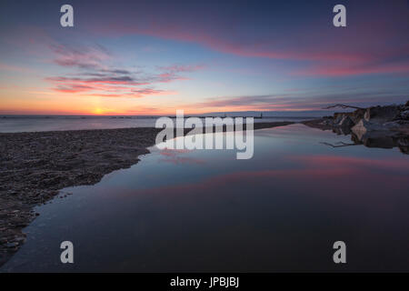 Rosa Himmel spiegelt sich im klaren Wasser im Morgengrauen Porto Recanati Provinz von Macerata Conero Riviera Marche Italien Europa Stockfoto