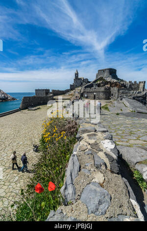 Blumen und blaues Meer umrahmen das alte Schloss und San Pietro Kirche Portovenere Provinz von La Spezia Ligurien Italien Europa Stockfoto