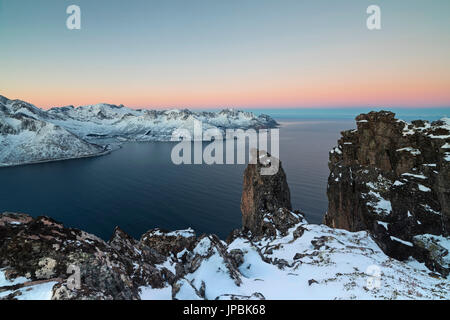 Blick auf die Mefjorden, umrahmt von gefrorenen Meer und rosa Himmel bei Sonnenaufgang von der Spitze des Mount Hesten Senja Tromsø Norwegen Europa Stockfoto