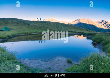 Silhouetten von Wanderern spiegeln sich im See mit Mont De La Saxe auf dem Hintergrund Courmayeur Aosta Tal Italien Europa Stockfoto