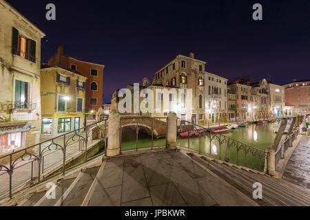 Nachtansicht der typischen Gondeln festgemacht in den Kanal, umgeben von alten Gebäuden und Brücken Venedig Veneto Italien Europa Stockfoto