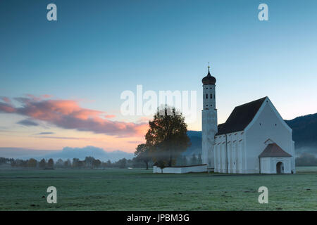 Rosa Wolken bei Sonnenaufgang am St. Coloman Kirche, umgeben von Wäldern Schwangau Bayern Deutschland Europa Stockfoto