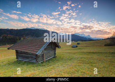 Sonnenuntergang am Holzhütten und Wiesen mit den Alpen im Hintergrund Geroldsee Krün Garmisch Partenkirchen oberen Bayern Deutschland Europa Stockfoto