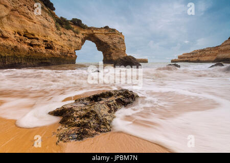 Wellen, die am Sandstrand umgeben von Klippen Albandeira Lagoa Gemeinde Algarve Portugal Europa Stockfoto