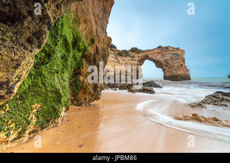 Wellen, die am Sandstrand umgeben von Klippen Albandeira Lagoa Gemeinde Algarve Portugal Europa Stockfoto