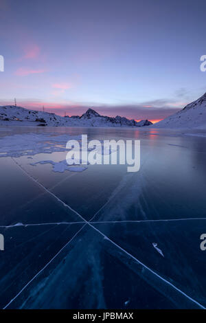 Die gefrorenen Lago Bianco umrahmt das erste Licht der Morgendämmerung Berninapass Kanton Graubünden-Engadin-Schweiz-Europa Stockfoto