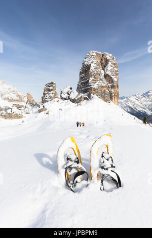 ein Blick auf die berühmte dolomitischen Gruppe namens Cinque Torri, mit einer Gruppe von Wanderern im Hintergrund und ein paar Schneeschuhe im Vordergrund, Belluno Provinz, Venetien, Italien, Europa Stockfoto