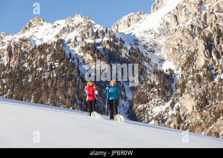 zwei Modelle gehen mit Schneeschuhen auf Neuschnee Gefühl, die Emotion des Pulver, Villnöss, Bozen Provinz, Südtirol, Trentino Alto Adige, Italien, Europa Stockfoto