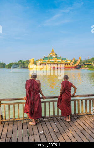 Yangon, Myanmar (Burma). Zwei Mönche Karaweik Palace am Kandawgyi See beobachten. Stockfoto