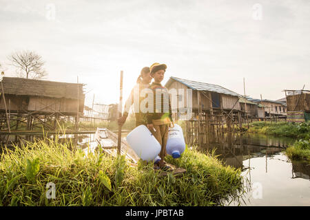 Inle-See, Nyaungshwe Township Taunggyi Bezirk, Myanmar (Burma). Mädchen und ein Kind auf einem Boot zwischen den schwimmenden Häusern am See. Stockfoto