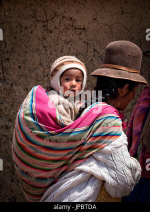 Aymara-Kind und seine Mutter mit der typischen Tracht gekleidet. Aymara sind die einheimische Bevölkerung des Gebiets Titicaca-See in Bolivien, Südamerika. Stockfoto