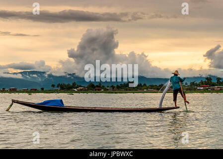 Inle-See, Myanmar, Südostasien. Ein Fischer im Gleichgewicht auf seinem Kanu. Stockfoto