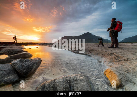 Mitternachtssonne rahmt Fotografen in Aktion am Skagsanden Strand Ramberg Nordland county Lofoten Inseln Norwegen Nordeuropa Stockfoto