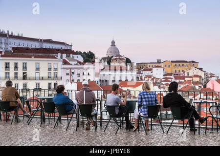 Touristen bewundern Terrakottadächer und antiken Kuppel von einer Terrasse am Aussichtspunkt Miradouro Alfama Lissabon Portugal Europa Stockfoto