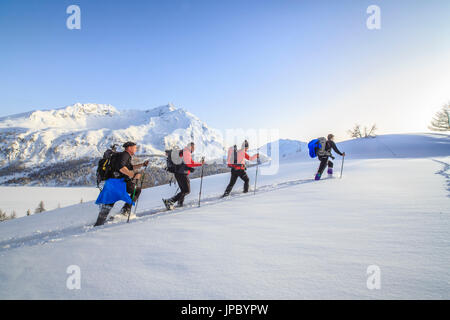 Schneeschuhwanderer sind auf dem Vormarsch in den frischen Schnee. Maloja-Pass. Engadin. Schweiz. Europa Stockfoto