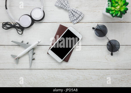 Ansicht von oben-Accessoires zu reisen mit Mann Kleidung concept.telephone,bow Krawatte, Pass auf hölzernen background.air Flugzeug, Sonnenbrille, Kopfhörer, Baum auf Holz t Stockfoto