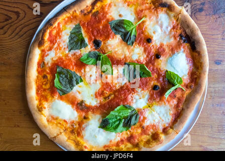 Pizza Margherita, ein klassisches Gericht aus Neapel, Italien, in den drei Farben der italienischen Flagge: Rot, weiß und grün – Tomaten, Käse und Basilikum Stockfoto