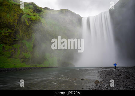 Island - Skogafoss Wasserfall mit Person Armen weit gedehnt Stockfoto