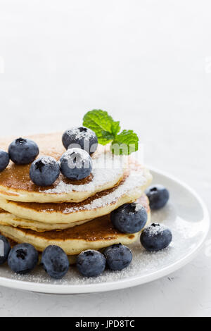 Heidelbeer-Buttermilch Pfannkuchen auf weisse Teller, gesundes Frühstück Stockfoto