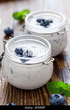 Gesunde Bio Heidelbeere Smoothies mit frischen Beeren in Gläsern auf rustikalen Holztisch Stockfoto