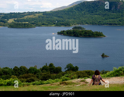 Frau saß ein Blick auf die Ansicht des Derwentwater, den Lake District, Cumbria, Großbritannien Stockfoto
