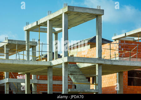 Baustelle Wohnungsbau Entwicklung, roten Backsteinmauer, Stahlbeton-Säulen, Treppe, unvollendet im Gange, mediterran, blau Stockfoto