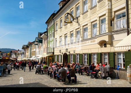 Leute sitzen in der Taverne vor historischen Häuserzeile, Marktstraße, Bad Tölz, Upper Bavaria, Bavaria, Germany Stockfoto