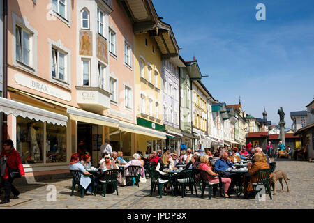 Leute sitzen im Cafe gegenüber historischen Häuserzeile, Marktstraße, Bad Tölz, Upper Bavaria, Bavaria, Germany Stockfoto