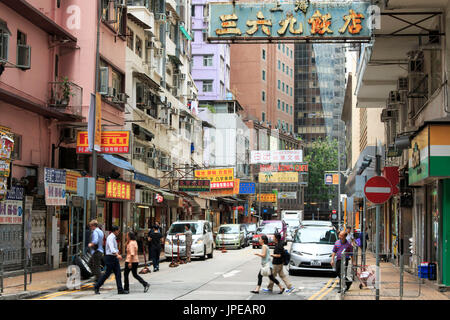 Detail einer Straße im Zentrum von Hongkong mit vielen Leuten auf der Straße. Auf Hintergrund lokale Geschäfte und Restaurants, China Stockfoto