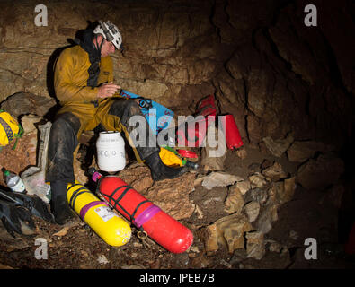 Tauchen in eine Höhle, Ligurien, Italien, Europa. Höhle Taucher Vorbereitung Ausrüstung mit seinem Swimfins und Tauchflaschen. Stockfoto