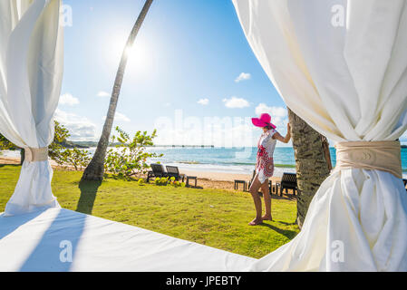 Playa Moron, Las Terrenas, Halbinsel Samaná, Dominikanische Republik. Schöne Frau, bewundern Sie die Aussicht von das Strand-Bett (MR). Stockfoto