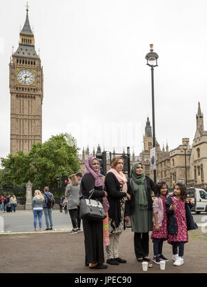 Eine asiatische Familie Pose für Fotos vor Big Ben und die Houses of Parliament in London, Vereinigtes Königreich. Stockfoto