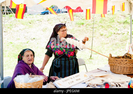 Frau spinnt Wolle auf dem Sonntagsmarkt in Arreau, Hautes-Pyrénées, Frankreich. Stockfoto