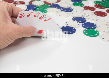 Spieler seine gewinnende Hand von Karten in einem Spiel von Poker, die Aufhebung der Ecke mit der Hand gerade Royal Flush in Herzen zeigen einsehen Stockfoto