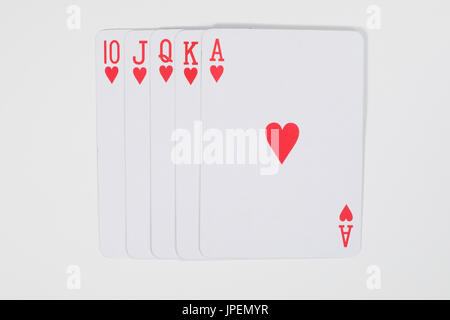 Höchste Karte Gewinnerhand beim Poker mit einem geraden Royal Flush in Herzen von oben gesehen auf weiß in einem Glücksspiel-Konzept Stockfoto