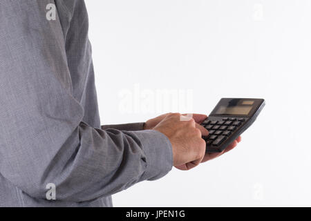 Mann tut eine Berechnung auf eine kleine einfache Taschenrechner in eine Nahaufnahme Seitenansicht seiner Hände isoliert auf weiss mit Textfreiraum Stockfoto