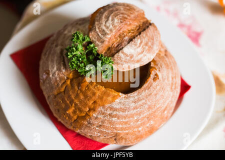 Gulaschsuppe im Brot in einer Schüssel Brot serviert. Stockfoto