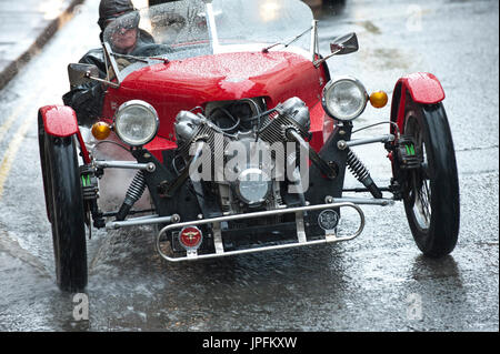 Builth Wells, Powys, UK. 1. August 2017. Ein Triking drei Wheeler Sportwagen sieht getrieben im Regen in der High Street, Builth Wells in Powys, Wales, Vereinigtes Königreich. Nach einem guten Start der Himmel bedeckt über und es gab schwere Regenschauer in Builth Wells in Powys, Wales, Vereinigtes Königreich. Bildnachweis: Graham M. Lawrence/Alamy Live-Nachrichten Stockfoto