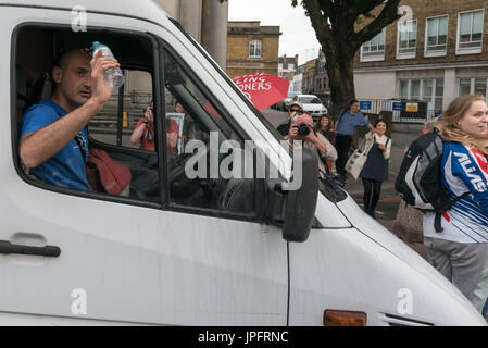 London, UK. 1. August 2017. Ein Mann in einem weißen Lieferwagen schleudert Wasser die Demonstranten, nachdem sie sich geweigert haben, zu bewegen, wenn er versucht, fahren durch den Rising Up Umwelt Demonstranten Blockiing Verkehr auf der belebten Marylebone Road unweit von Baker St für einen zweiten "Staying Alive" Straßensperre Disco Protest zu sensibilisieren und rufen zu dringendem Handeln über die hohe Schadstoffbelastung von Verkehr auf den Straßen Londons, die 10.000 vorzeitige Todesfälle pro Jahr verursachen. Sie standen und saßen auf der Straße vor dem Wagen und schob ihn zurück, als er versuchte, befahren.  Peter Marshall/Alamy Live-Nachrichten Stockfoto