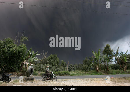 Nord-Sumatra, Indonesien. 2. August 2017. Ein Mann reitet auf seinem Motorrad vor vulkanische Materialien spie von Mount Sinabung in Karo, Nord-Sumatra, Indonesien, auf 2. August 2017. Bildnachweis: YT Haryono/Xinhua/Alamy Live-Nachrichten Stockfoto