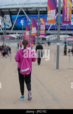 London, UK. 2. August 2017. Ein freiwilliger, bekannt als "Runner", in offizieller Uniform gekleidet durch den Olympiapark auf dem Weg zum Stadion London geht. Die IAAF Weltmeisterschaften London 2017 beginnen offiziell am 4. August, aber Teams von Freiwilligen und Mitarbeiter sind beschäftigt mit den Vorbereitungen für die Eröffnung der Veranstaltung. Bildnachweis: Stephen Chung/Alamy Live-Nachrichten Stockfoto