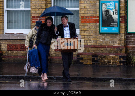 Lewes, UK. 2. August 2017. Großbritannien Wetter. Junge Menschen kommen zu Lewes Bahnhof im Regen auf dem Weg zum Glyndebourne Opera House für eine Aufführung von Don Pasquale, Lewes, East Sussex, UK. Bildnachweis: Grant Rooney/Alamy Live-Nachrichten Stockfoto