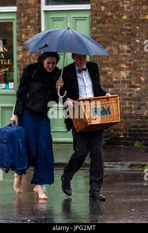 Lewes, UK. 2. August 2017. Großbritannien Wetter. Junge Menschen kommen zu Lewes Bahnhof im Regen auf dem Weg zum Glyndebourne Opera House für eine Aufführung von Don Pasquale, Lewes, East Sussex, UK. Bildnachweis: Grant Rooney/Alamy Live-Nachrichten Stockfoto